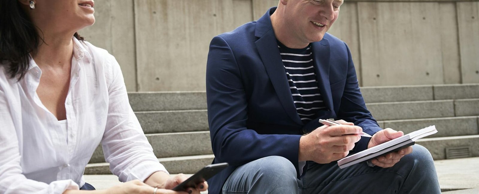 woman and man having a discussion while sitting on steps